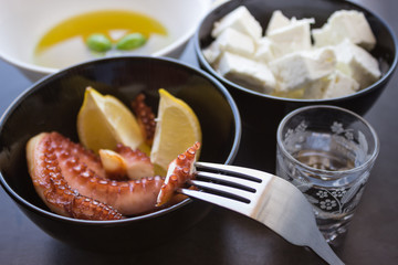 Baked octopus. Traditional Greek snacks. Olives . Selective focus.