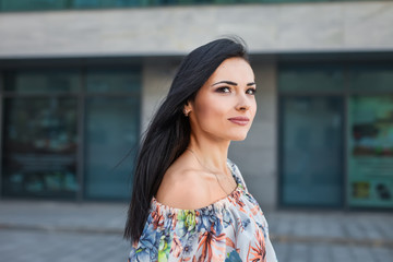 portrait of young attractive teen in the city, looking left. concept of freedom purposeful teenager, dressed in a summer dress with flower pattern