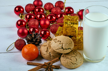 Perfect treat for Santa Claus. A glass of milk, oatmeal dietary cookies, fragrant spices and New Year's, Christmas decorations. Treats for Christmas Eve.