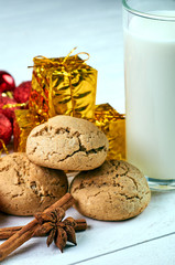 Perfect treat for Santa Claus. A glass of milk, oatmeal dietary cookies, fragrant spices and New Year's, Christmas decorations. Treats for Christmas Eve.