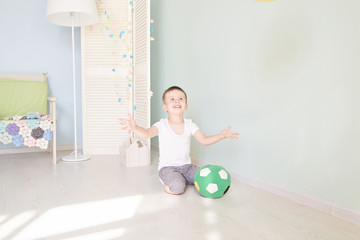 Full length portrait of a child with a soccer ball isolated in home