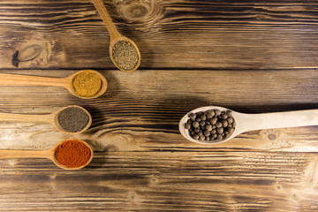 Assorted spices in wooden spoons on a table