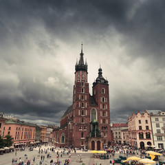 Church of St. Mary in the main Market Square on the background of dramatic sky. Basilica Mariacka. Krakow. Poland.