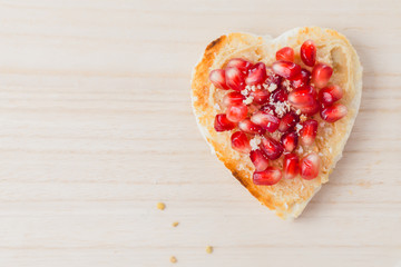 Valentine's day concept, toast  heart  pomegranate seeds, copy space
