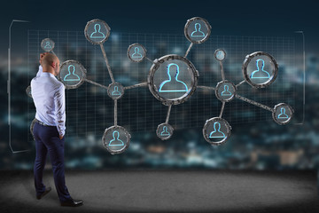 Businessman in front of a wall with network connection with people linked each other in technology wheel - 3d rendering