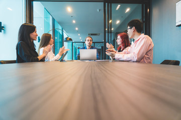 Young casual dressed people group in modern office have team meeting and brainstorming, while some working on laptop, papers and tablets. Copy space