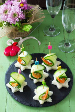 Canape with white bread, cucumber, ricotta and royal prawn on a festive table. Valentine's day concept or wedding.