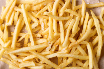 french fries background, potatoes chips with salt. close-up shot. top view