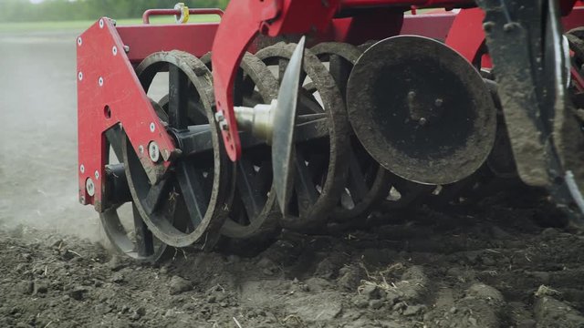Blades cultivator and seeder sowing machine working on agricultural field. Agricultural machinery for scattering seeds moving on farmer field