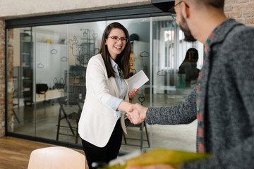 Openly greeting a job recruiter with a firm handshake - obrazy, fototapety, plakaty