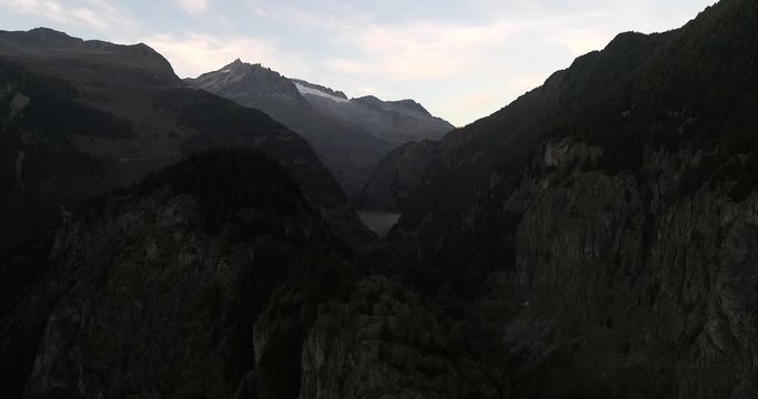 Mountain dam, Cinema 4k aerial view towards a dam between alpines, on a sunny autumn evening dawn, near blatten bei naters, Valais, in the alps of Switzerland