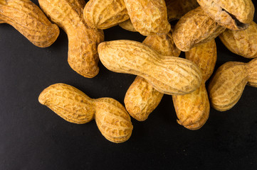 Peanuts in shell on dark background, close up
