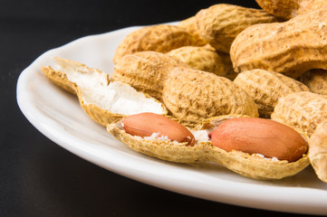 Peanuts in shell on dark background, close up