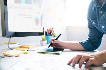 Graphic designer using graphics tablet to do work at desk