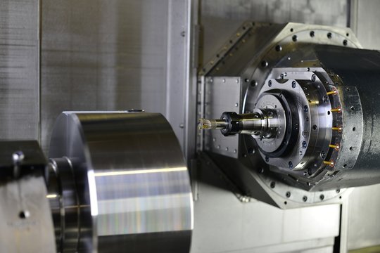 The 5-axis CNC machine while cutting the sample part of turbine.The spindle of 5 axis CNC machining center white cutting turbine sample part.