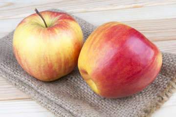 red apples on burlap and on a wooden background