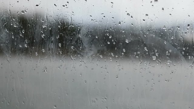 Raindrops running down on a window glass.