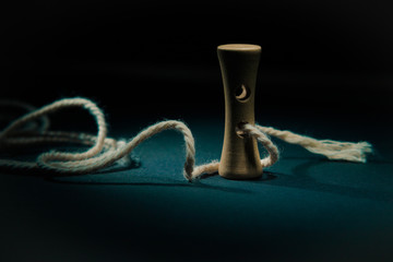 Wooden button with rope in light painting.