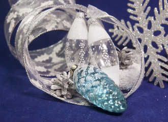 Fototapeta premium The glass New Year's cone, toys of an icicle and a New Year's tape on a blue background