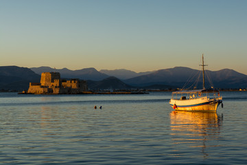 A small wooden boat in Nafplio, Greece with Bourtzi view on the background
