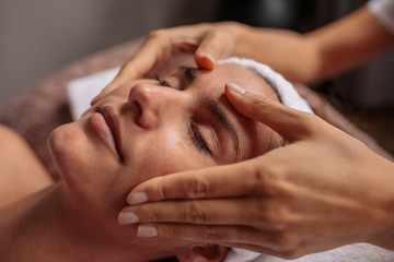 Beautiful woman relaxing with face massage at beauty spa