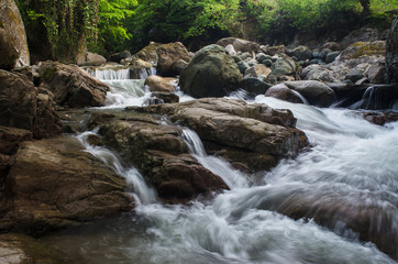 the mountain river flows among the stones.