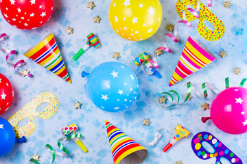 Obraz premium Bright colorful carnival or party pattern of balloons, streamers and confetti on blue table. Flat lay style, birthday or party greeting card.