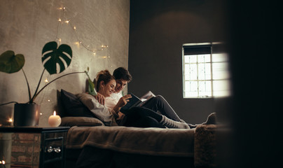 Couple on bed reading book