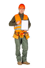male builder or manual worker in helmet holding a clipboard and shows with a pencil on the clipboard over white wall background.