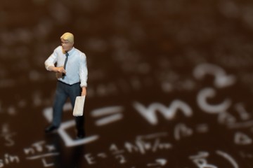 Fototapeta premium miniatura di insegnante di matematica sopra formule scritte a mano