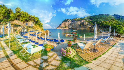 Sunbeds and umbrella on the beach in Corfu Island, Greece.