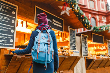 Obraz na płótnie Canvas Traveler woman choosing Christmas gifts at market in New Year time