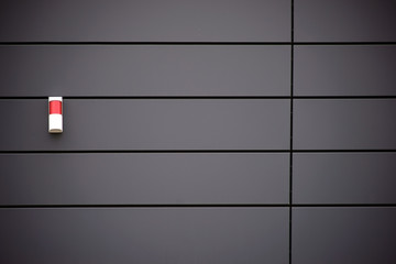 Metallfassade mit Alarmanlage / Eine moderne Hausfassade aus Metallpaneelen mit einer Warnleuchte.
