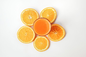 A glass of orange juice with orange slices on white background. Vitamins on top view
