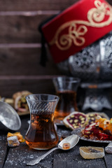 Traditional Turkish tea with traditional oriental sweets, dark background