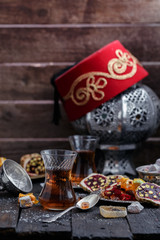 Turkish tea with authentic glass cups. Two cups of turkish tea and sweets on dark wood background