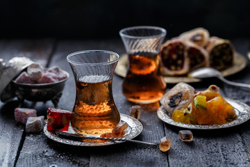 A glowing traditional glass of tea with blurred dark background