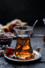 A glowing traditional glass of tea with blurred dark background