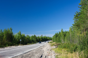 Fototapeta na wymiar Asphalt road with driving cars in forest at summer