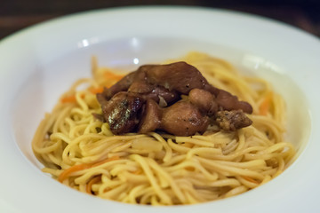 Fried noodles with vegetables and chicken in pepper sauce