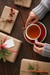 Woman sitting on the desk with christmas gift box. Hands of woman