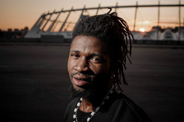 afro-american man with dreadlocks with meditative look and steel earing