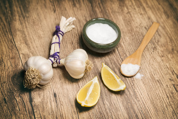 Garlic Bulbs, Lemons And Salt On A Wooden Surface