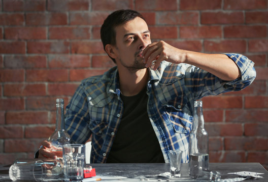 Man drinking alcohol while sitting at table