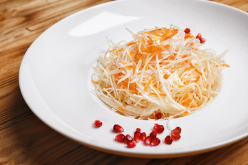 Plate with fresh vegetable salad on wooden table, closeup