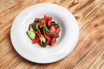 Plate with fresh vegetable salad on wooden table