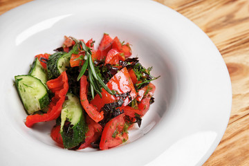 Plate with fresh vegetable salad on wooden table, closeup