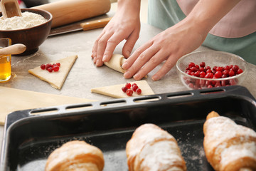 Woman preparing puff pastry at table