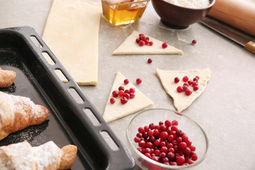 Raw puff pastry with berries on table