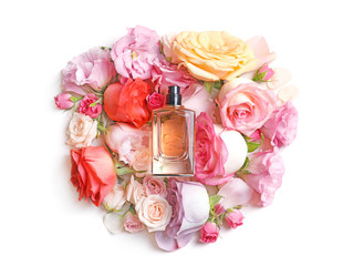 Bottle of perfume with flowers on light background